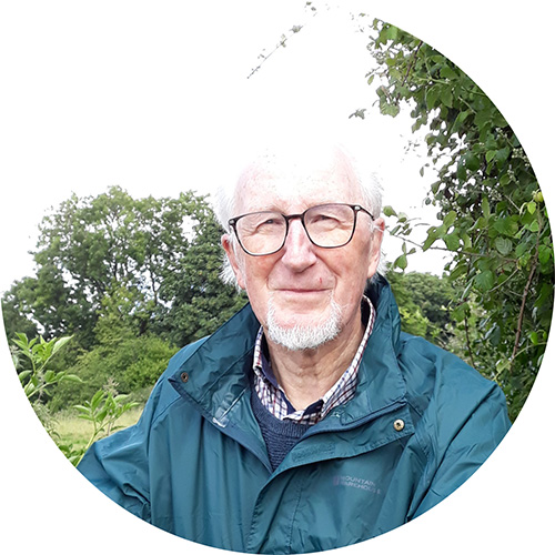 a happy man outside, standing by a gate